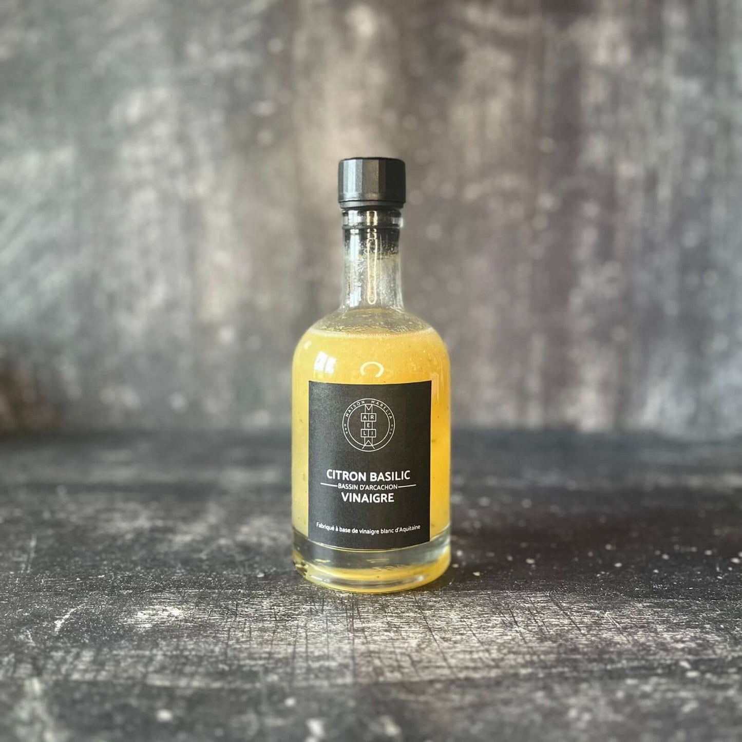 Vinaigre Citron Basilic sur fond bois gris