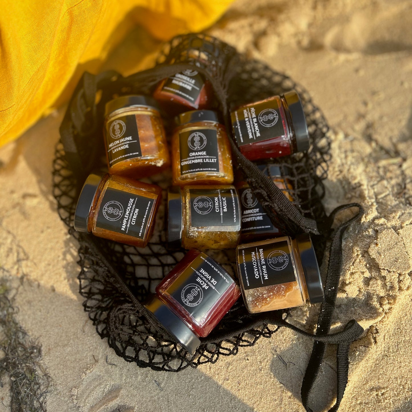 Regroupement de confitures Marelia dans un sac sur le sable